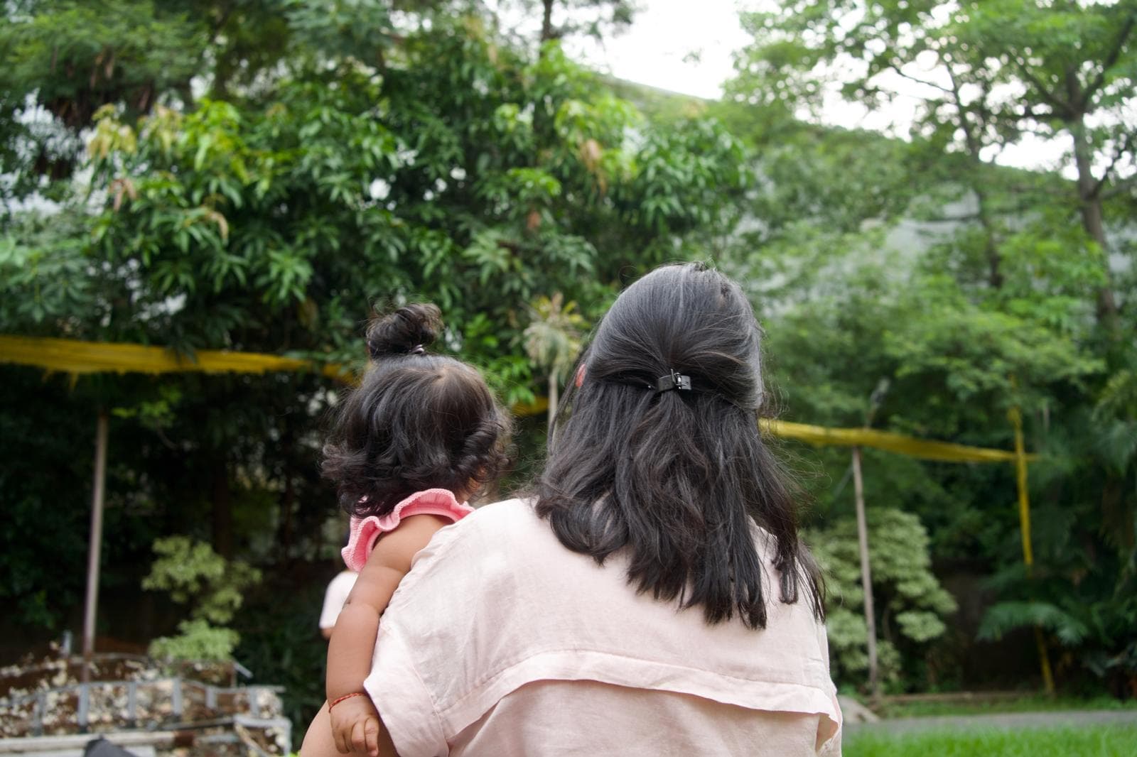 Joy holding her daughter, looking out over a garden